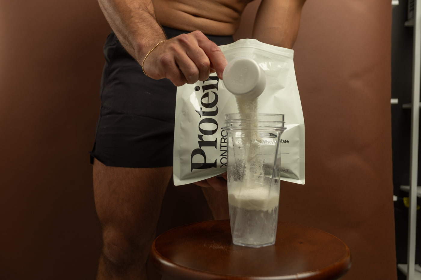 A scoop of Protein Control going into a shaker